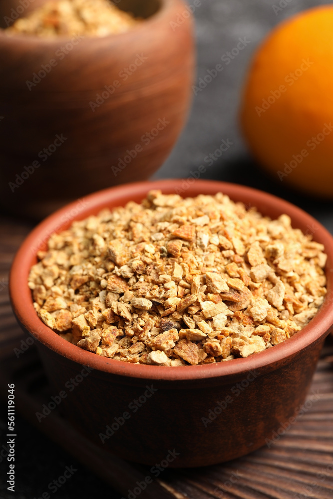 Bowl of dried orange zest seasoning, fresh fruit and anise on grey table Bowl of dried orange zest seasoning, fresh fruit and anise on grey table