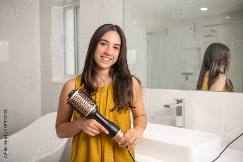 latin girl with hair dryer brush