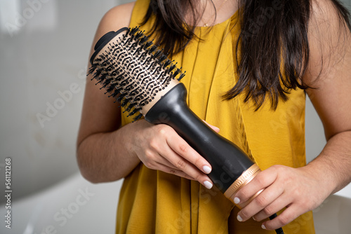 teenager holding a hair dryer brush