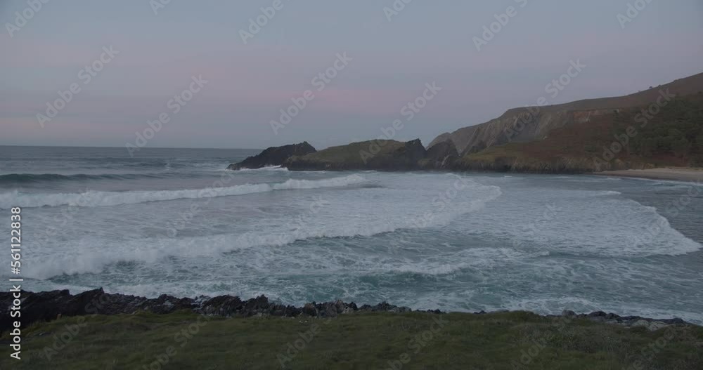 Big waves rolling into a deserted bay after sunset during blue hour in Galicia, Spain Big waves rolling into a deserted bay after sunset during blue hour in Galicia, Spain