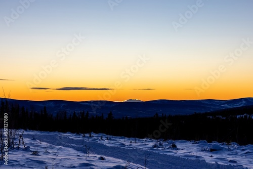Serene Sunset winter landscape in Fairbanks Alaska with view of the peak of mount Denali in horizon © Jon