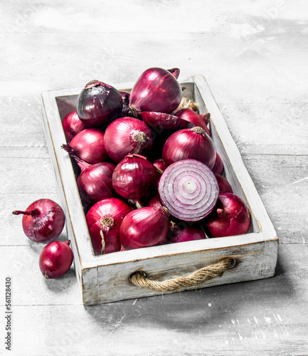 Red onion whole and sliced on tray.