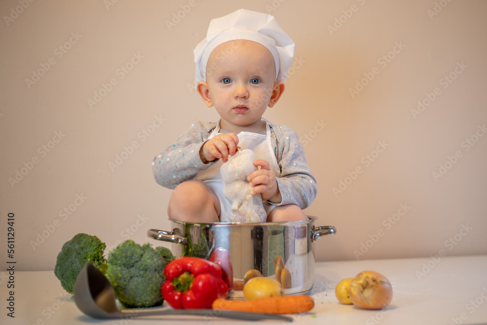 Little female chef preparing vegetable soup in kitchen. Little female chef preparing vegetable soup in kitchen.