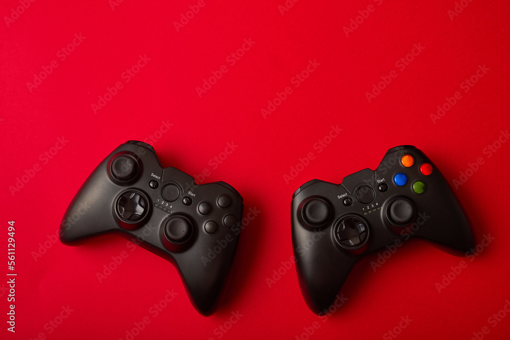 Black video game controller, joystick for game console isolated on red background. Gamer control device close-up Black video game controller, joystick for game console isolated on red background. Gamer control device close-up