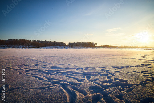 Photo of a sunset at winter snowy field  peaceful stunning landscape  amazing seasonal nature  cold weather in the park  beautiful sunny snow field  wintertime scene  icy lands