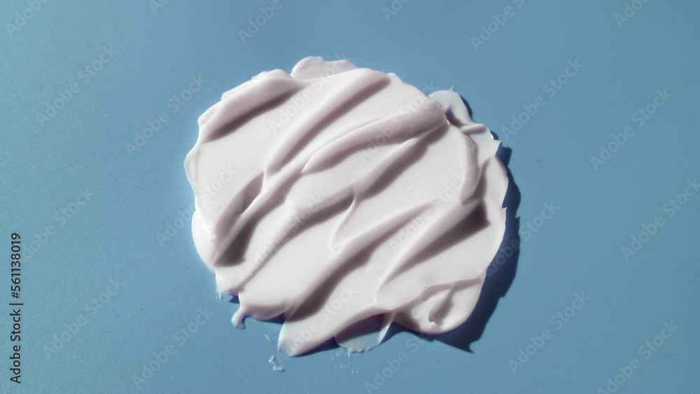 Macro crane shot of white nourishing cream smears on blue background | Nourishing cream commercial Macro crane shot of white nourishing cream smears on blue background | Nourishing cream commercial