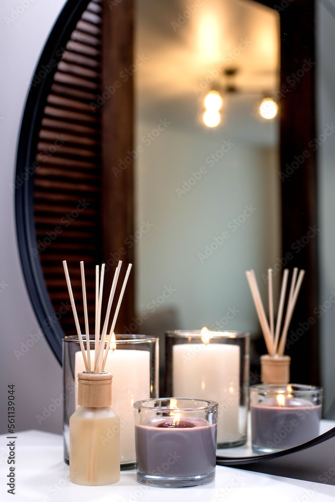 Air freshener in a glass bottle and scented candles in candle holders. Home atmosphere. Fragrances for the home Air freshener in a glass bottle and scented candles in candle holders. Home atmosphere. Fragrances for the home