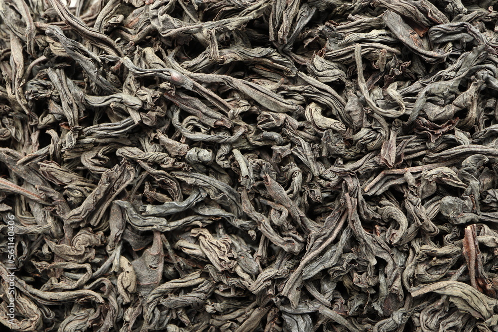Close-up macro shot of the dry black tea leaves lying on a flat surface. Close-up macro shot of the dry black tea leaves lying on a flat surface.