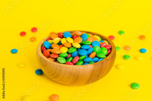 Multicolored candies in a bowl on a colored background. birthday and holiday concept. Top view with copy space