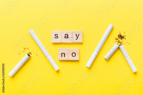 Cigarette And Wooden Blocks, Broken cigarette on table background, No Tobacco Day with hourglass, clock health concept. time to quit smoking