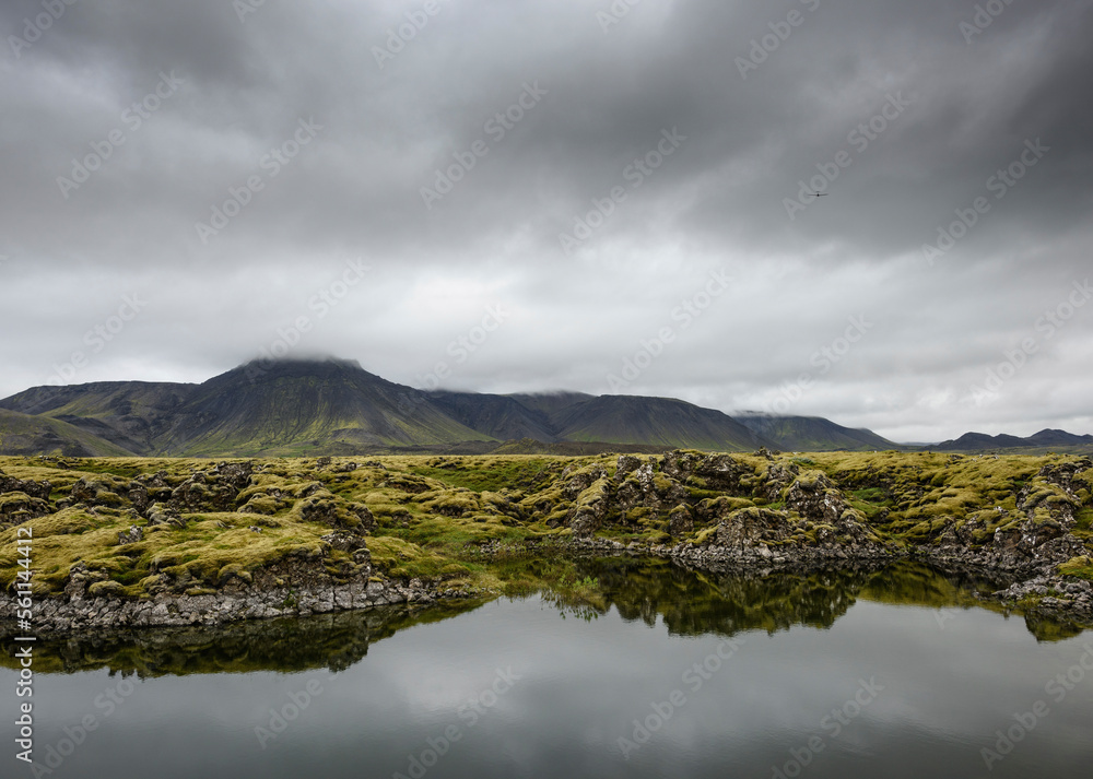 Idyllic view of lake against mountains and stormy clouds Idyllic view of lake against mountains and stormy clouds