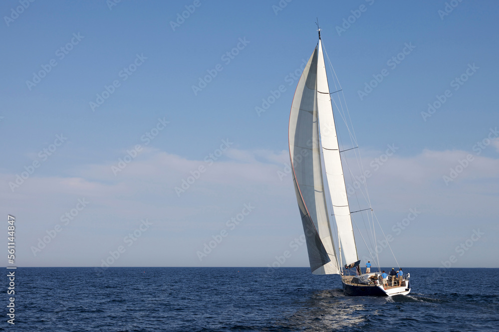A crew races a modern ocean-going sailing yacht. A crew races a modern ocean-going sailing yacht.