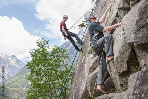 Two male rock climbers scaling a rock face at Oberried climbing garden, Otztal, Tyrol, Austria photo