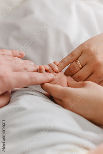 parents holding newborn hand