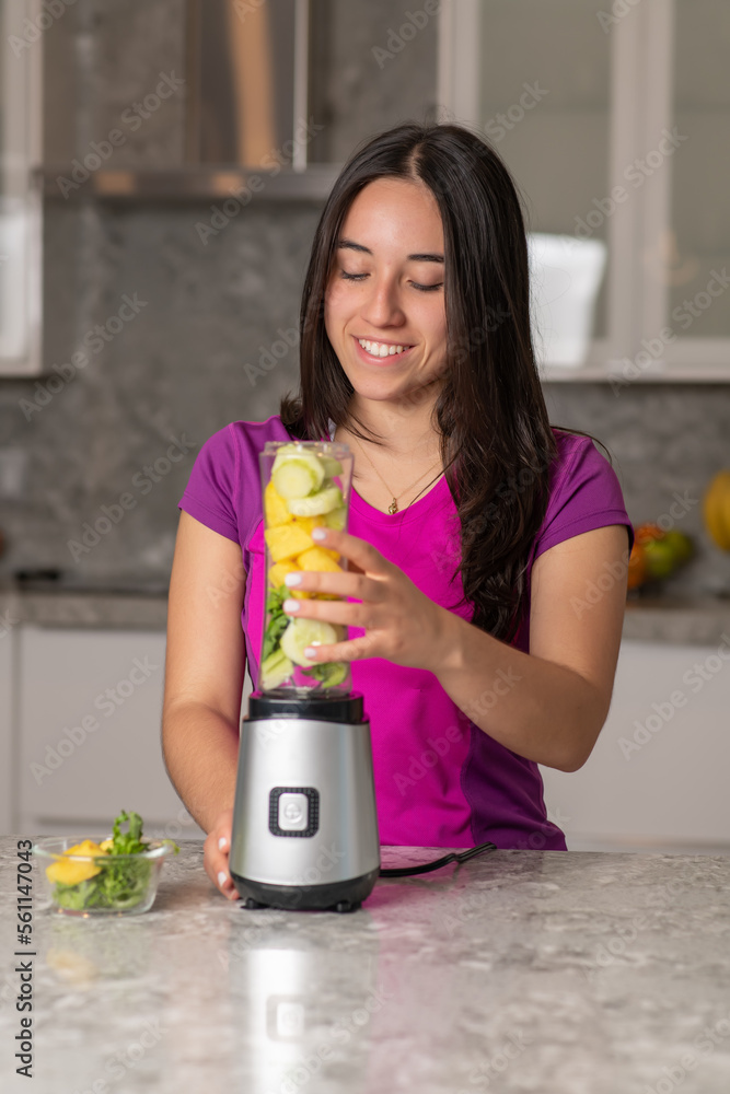 latin teen preparing a smoothie on a kitchen