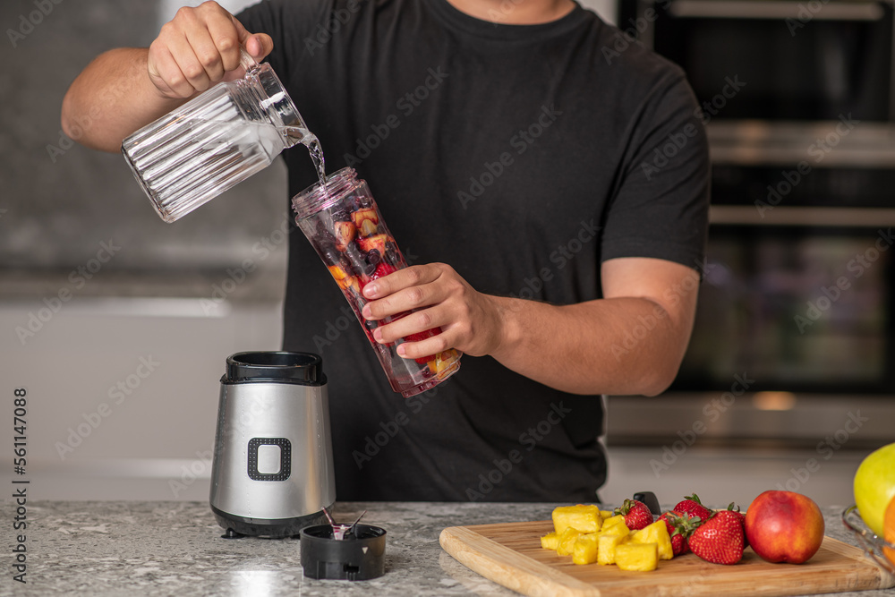 hispanic teenager preparing a smoothie on a blender