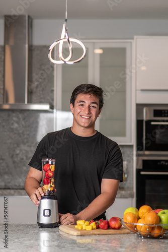 hispanic teenager preparing a smoothie on a blender