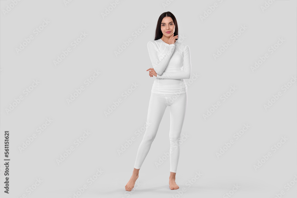 Woman in warm thermal underwear on light background. Space for text - obrazy, fototapety, plakaty 