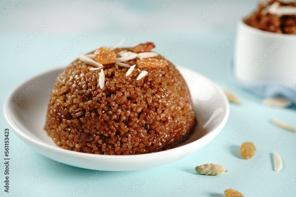 Homemade broken wheat sweet chakarai pongal topped with nuts and raisins, selective focus Homemade broken wheat sweet chakarai pongal topped with nuts and raisins, selective focus