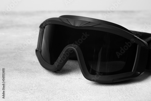 Tactical glasses on light gray background, closeup. Military training equipment photo