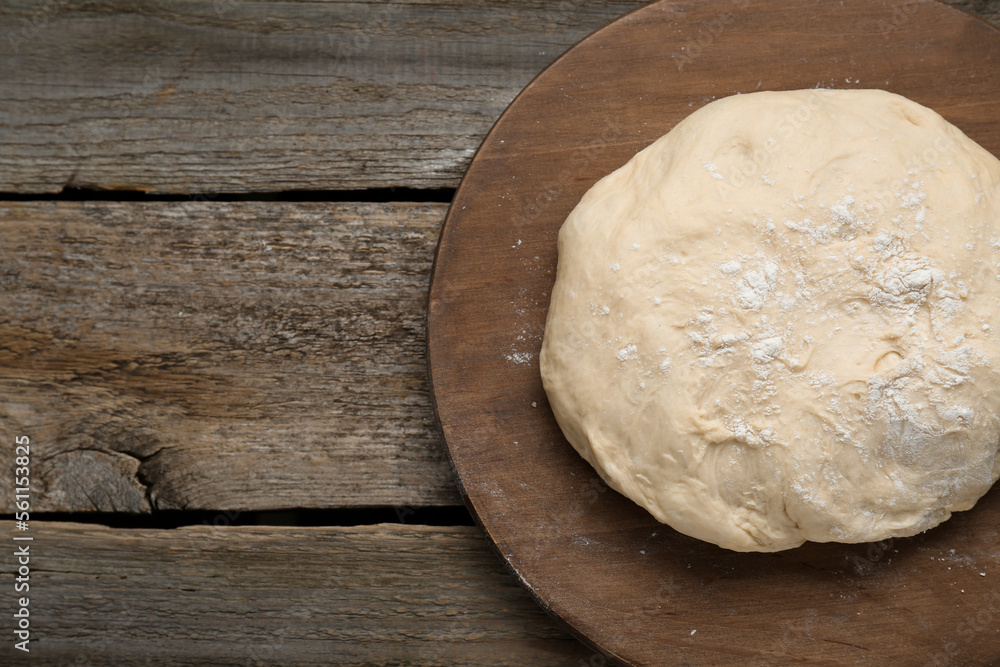 Fresh yeast dough with flour on wooden table, top view. Space for text Fresh yeast dough with flour on wooden table, top view. Space for text