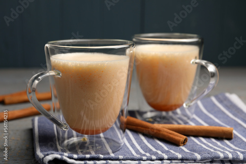 Delicious eggnog with cinnamon on grey wooden table