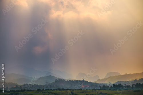 Dramatic rays of light breaking through clouds over a mountainous landscape at Phong Nha in Vietnam