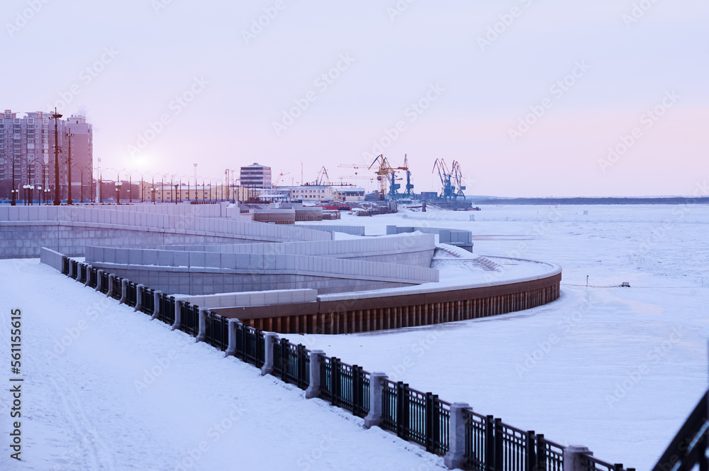 Snow on the river embankment on a winter morning. View of the river port. Fences and stairways Snow on the river embankment on a winter morning. View of the river port. Fences and stairways