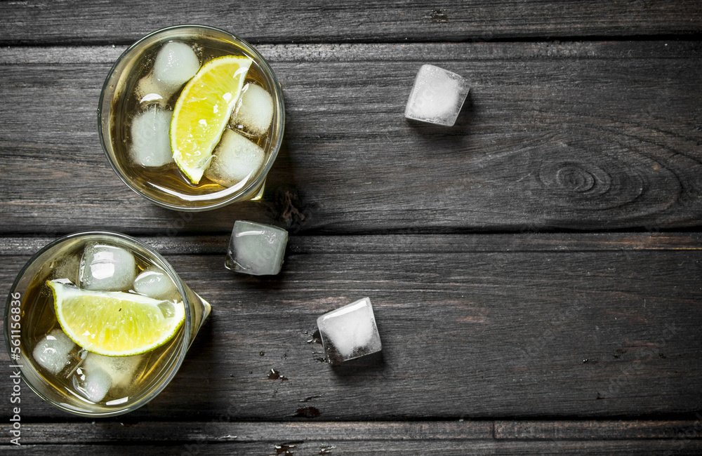 Whisky in glasses with ice and lime slices. Whisky in glasses with ice and lime slices.