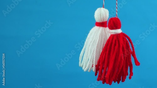 Traditional Martisor - symbol of holiday 1 March, Martenitsa, Baba Marta, beginning of spring and seasons changing in Romania, Bulgaria, Moldova. Greeting and post card for holidays. Blue background. photo