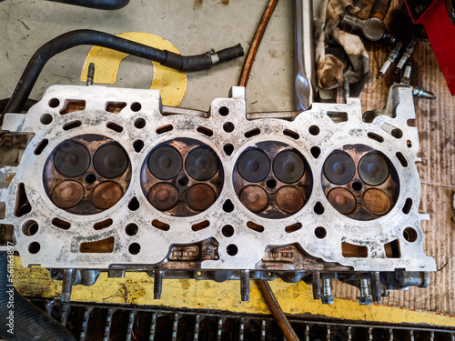 combustion chamber in the cylinder head of a gasoline engine vehicle being overhauled in a garage photo