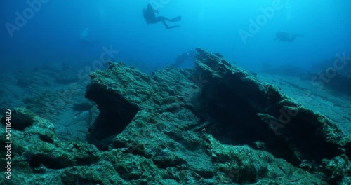 Wallpaper Mural  scuba diver exploring around a reef underwater deep blue water big rocks and bubbles ocean scenery Torontodigital.ca