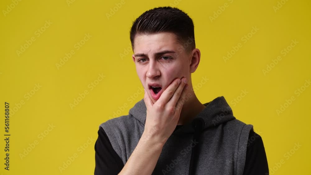 4k slow motion video of one man touching his chin over yellow background. 4k slow motion video of one man touching his chin over yellow background.