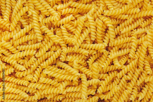 Raw dry fusilli pasta, food background texture, top view