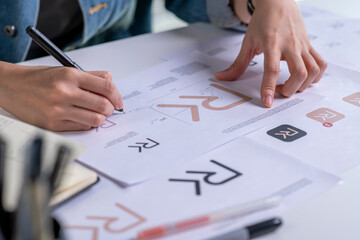 Graphic designer drawing sketches logo design. The concept of a new brand. Professional creative occupation with idea.