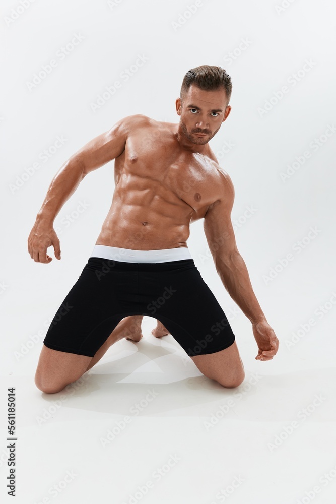 Obraz premium Man athletic body bodybuilder in briefs with naked torso abs full-length in the background, fitness classes. Advertising, sports, active lifestyle, competition, challenge concept.