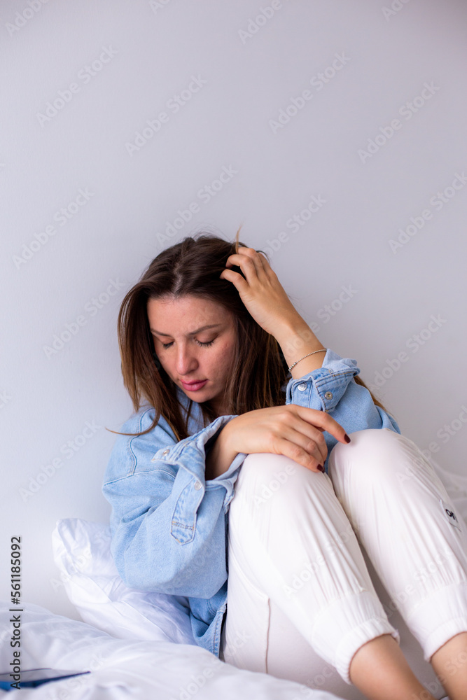 Stressed young woman holding head in hands, depressed about financial problems, sitting on sofa in living room. Stressed young woman holding head in hands, depressed about financial problems, sitting on sofa in living room.