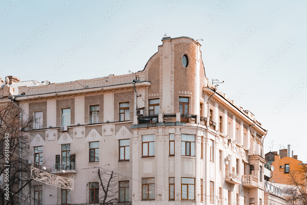 Ancient facade of the old building with stucco elevation and decorative dormer oval window on the top. Architecture. History. Heritage. Residential. Europe