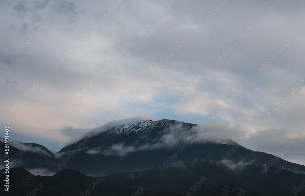 The peaks of the mountains in the snow shrouded in clouds, natural background, the idea of a landscape about winter on the Mediterranean coast. The peaks of the mountains in the snow shrouded in clouds, natural background, the idea of a landscape about winter on the Mediterranean coast.