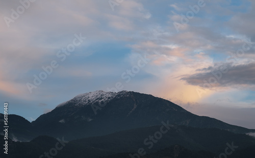 Distant mountain peaks in the snow against the sunset sky, mountain landscape, idea for a background or wallpaper