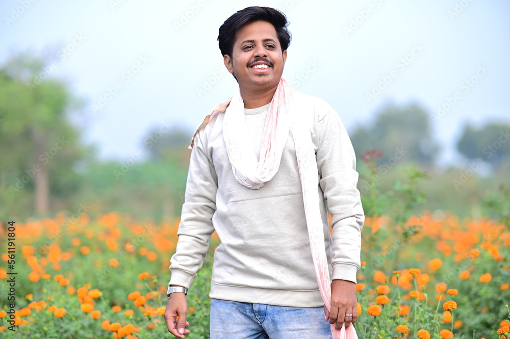 Indian Man in White shirt in the field with white scarf. Flower Field. Travel advertisement