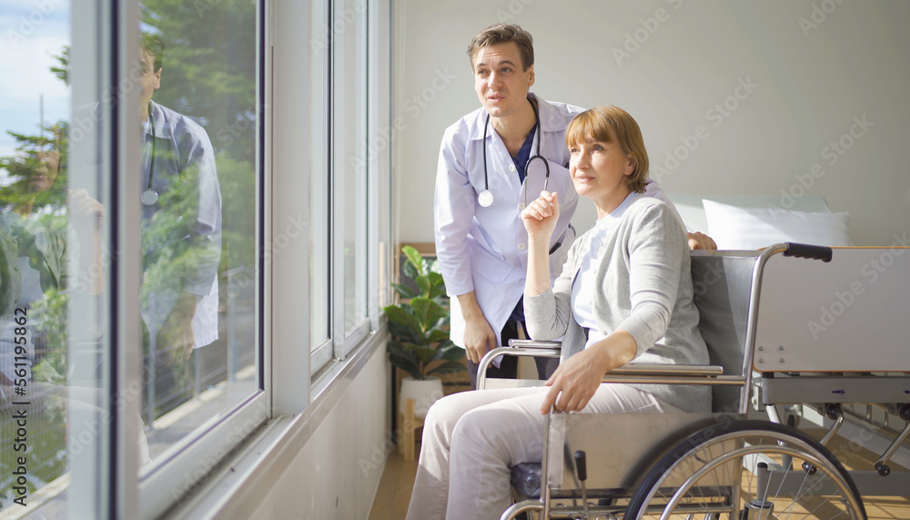 Portrait of caucasian doctor check up body of disabled old senior elderly patient using wheelchair try to walk in hospital in medical and healthcare treatment at nursing home. People lifestyle