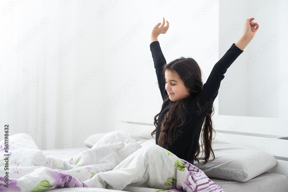 people, bedtime and rest concept - happy smiling teenage girl stretching in bed at home in morning people, bedtime and rest concept - happy smiling teenage girl stretching in bed at home in morning