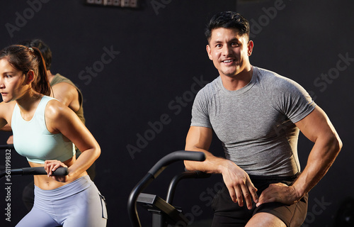 young athletic man cycling exercise bikes at the gym