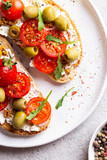 Bruschettas with olives and fresh tomatoes and wineglass