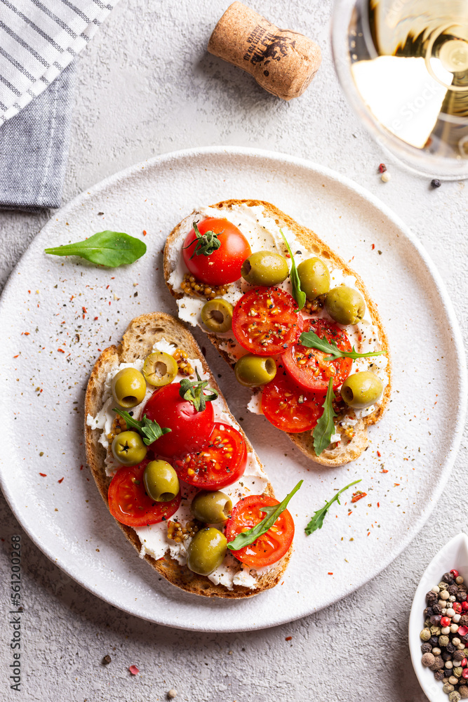 Bruschettas with olives and fresh tomatoes and wineglass Bruschettas with olives and fresh tomatoes and wineglass