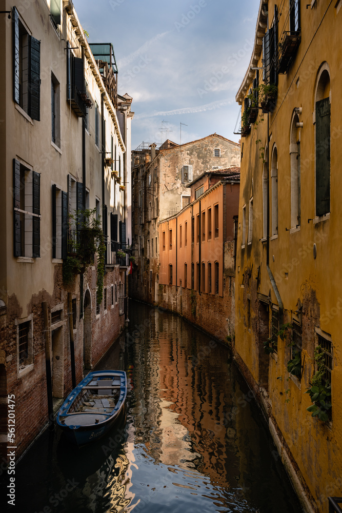 Small Canal with Moored Boat in Venice, Italy with Romantic old Houses