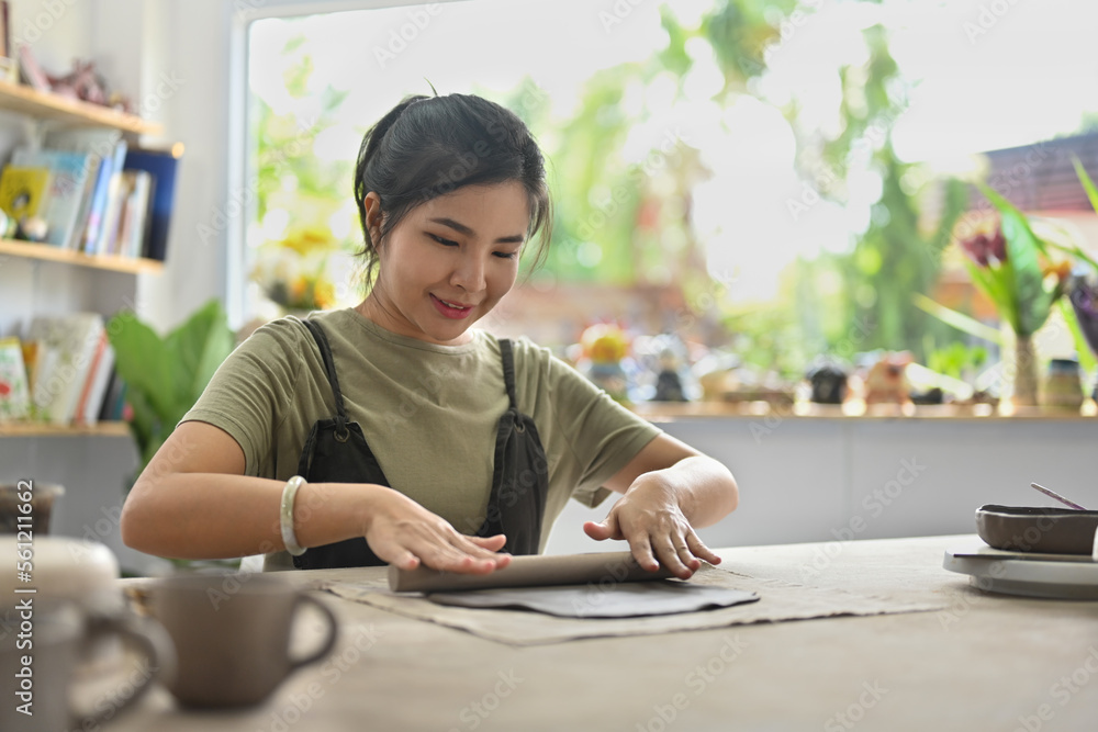 Asian woman working neatly with dough to make a ceramic object. Asian woman working neatly with dough to make a ceramic object.