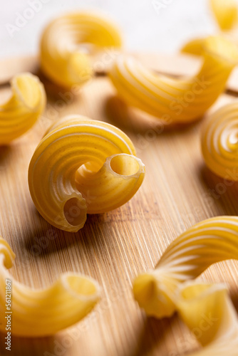 Raw pasta on a wooden board photo