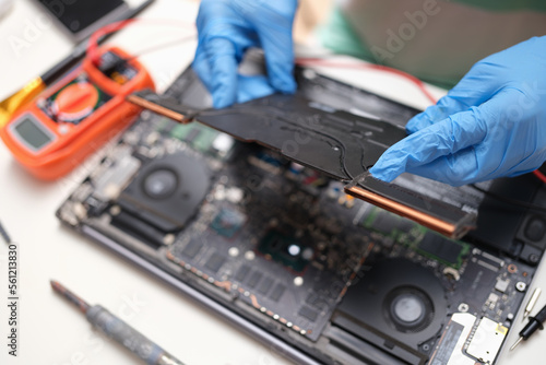 PC repair technician with laptop on background of hardware technologies and computer motherboard